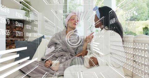 Relaxing spa day at home with two women chatting on sofa featuring ar laptop graphics
