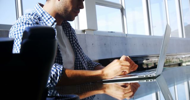 Focused Young Man Using Laptop in Bright Office Setting - Download Free Stock Images Pikwizard.com