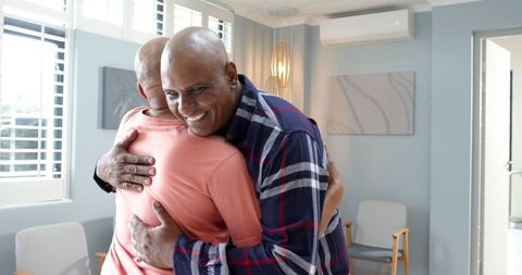 Senior Friends Hugging in Cozy Living Room Environment