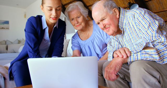 Young Professional Assisting Elderly Couple with Technology - Download Free Stock Images Pikwizard.com