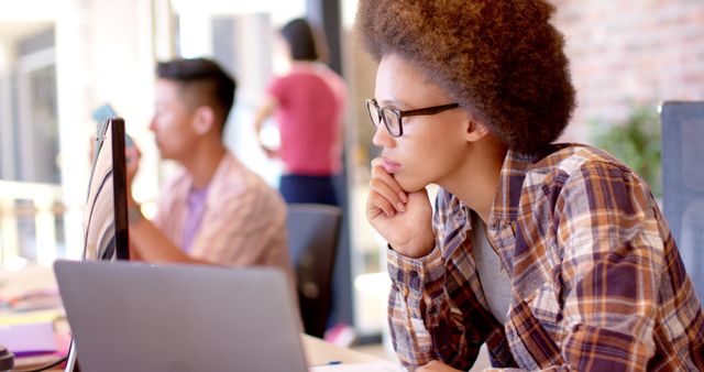 Thoughtful biracial woman using computer at desk in casual office, slow motion - Download Free Stock Photos Pikwizard.com