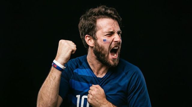 Passionate american soccer fan celebrating goal with fist pump and usa face flag sticker