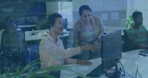 Female colleagues analyzing data on computer in modern office