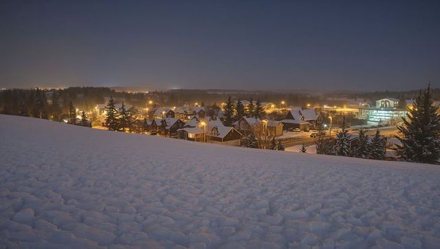 Snow-Covered Hillside Overlooking Glowing Suburban Neighborhood Twilight Panorama