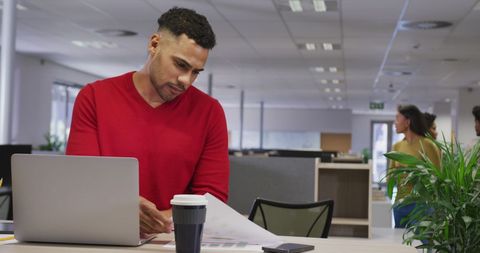 Focused Business Professional Reviewing Documents at Office Desk