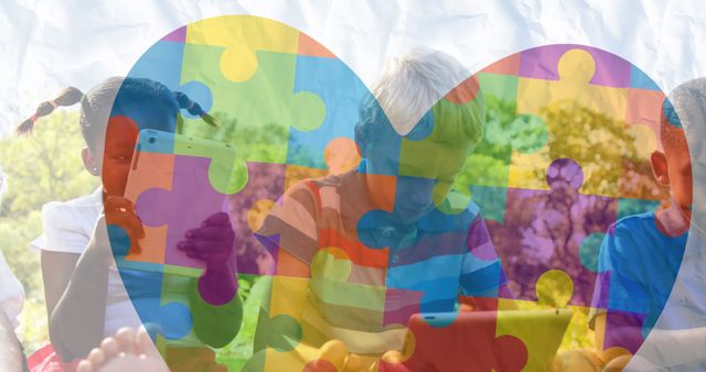 Image of colorful puzzle pieces heart over happy playing children. autism, learning difficulties, support and awareness concept digitally generated image.