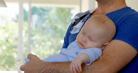 Father Holding Sleeping Baby Peacefully at Home