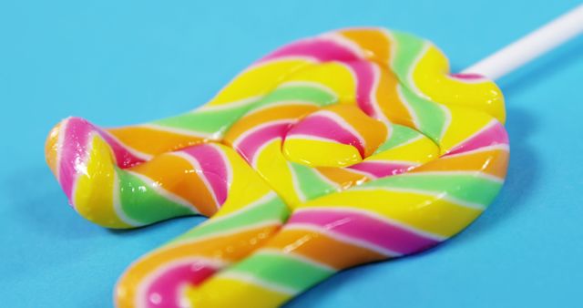 Close-Up of Colorful Swirled Lollipop Against Blue Background - Download Free Stock Images Pikwizard.com