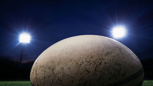 Close-up of Glowing Rugby Ball on Field at Night