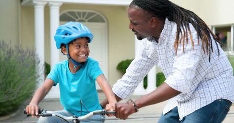 Father and Son Bonding Over Learning to Ride Bicycle Outdoors