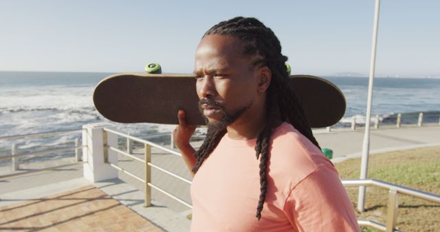 African American Man Relaxing with Skateboard by Ocean - Download Free Stock Images Pikwizard.com