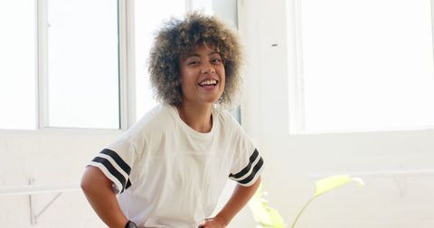 Cheerful Young Woman Smiling in Bright Room