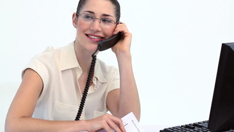 Smiling Businesswoman on Phone in Office with Computer and Notes