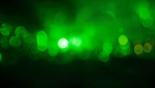 Glowing green bokeh with hazy central orb, neon circles and diffuse luminosity