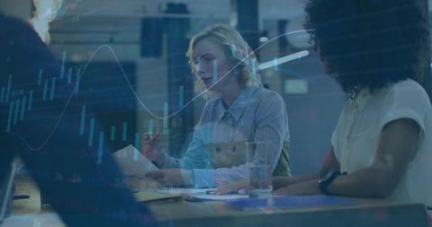 Professionals analyzing financial reports with market charts overlay in modern office