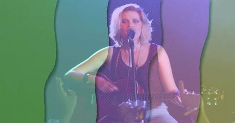 Woman Playing Guitar Singing on Dimly Lit Club Stage