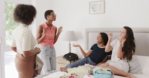 Friends Packing Suitcase and Chatting at Home