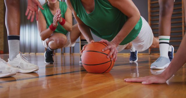 Diverse female basketball team wearing sportswear and doing push ups. basketball, sports training at an indoor court.