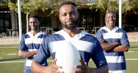 Confident rugby players posing proudly on field