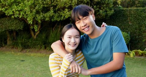 Young Asian Couple Embracing Joyfully Outdoors