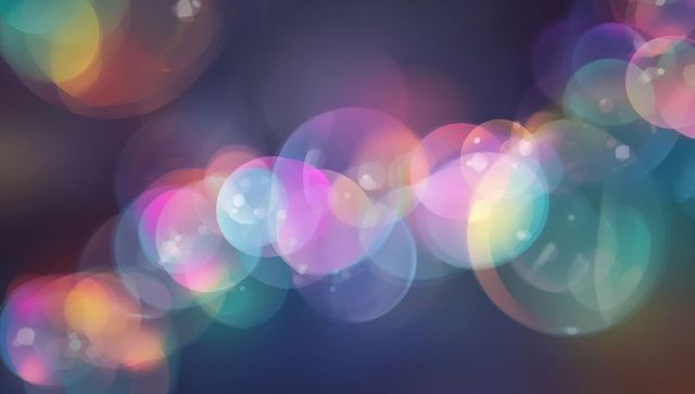 Neon bokeh orbs drifting across dark gradient background with pastel glowing halos