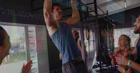 Strong athletes encouraging pull-up performance in gym setting