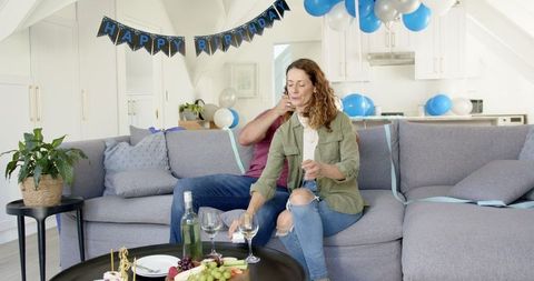Mature Couple Celebrating Birthday with Wine and Snacks