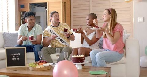 Friends celebrating new job with cake and champagne