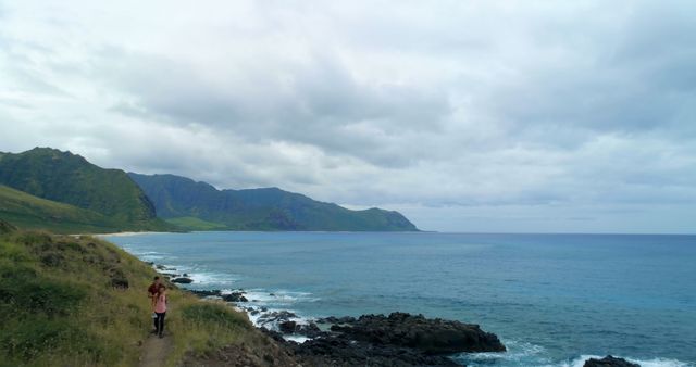 Woman Walking on Cliffside Trail by the Ocean - Download Free Stock Images Pikwizard.com
