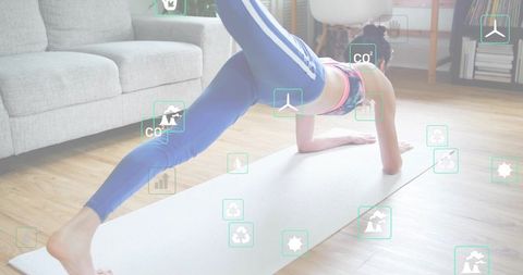 Korean woman performing one-leg plank on yoga mat at home with green eco icons