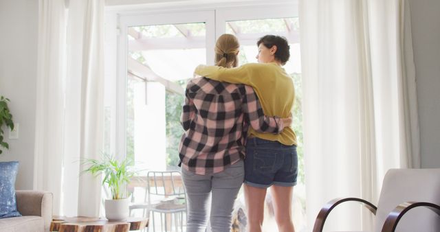 Rear view of caucasian lesbian couple hugging each other at home. lgbt relationship and lifestyle concept