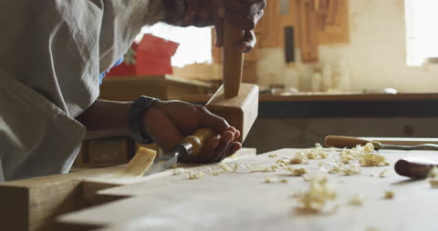 Senior Carpenter Skillfully Using Chisel in Workshop
