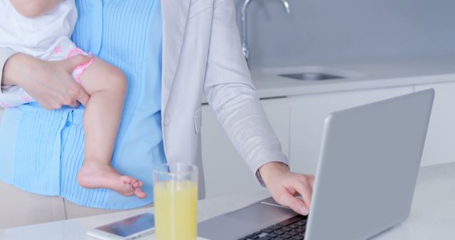 Working Mother Balancing Baby and Laptop in Kitchen - Download Free Stock Images Pikwizard.com