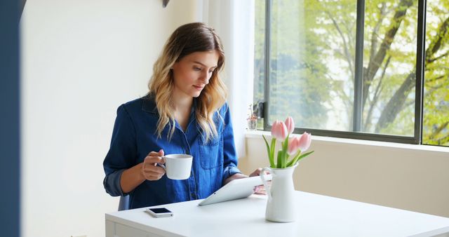 Young Woman Drinking Coffee and Using Tablet at Home Office - Download Free Stock Images Pikwizard.com