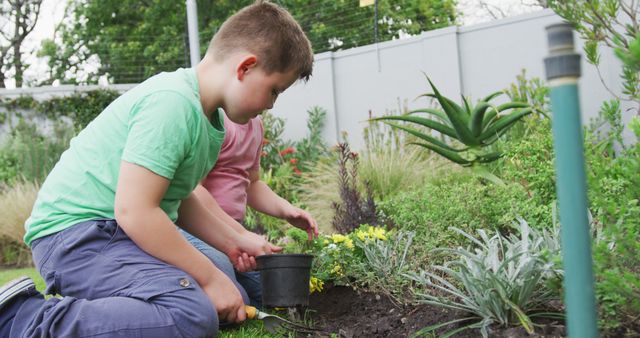 Happy caucasian boy with his brother gardening together in garden. family spending time at home.