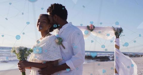Black couple embracing at oceanfront wedding golden hour floral arch coastal ceremony