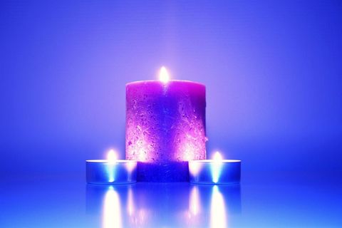 Purple Candle with Tealights on Reflective Surface