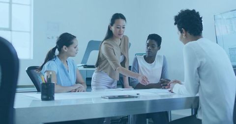 Women Collaborating Over Architectural Plans and Tablet in Modern Office