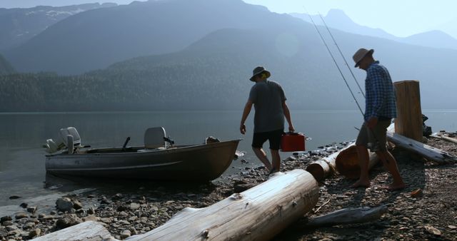 Two men are preparing a boat for a fishing trip on a serene lake surrounded by mountains. They carry fishing gear and fuel, ready to embark on their adventure. Ideal for use in travel blogs, outdoor activity promotions, and nature websites highlighting peaceful retreats.