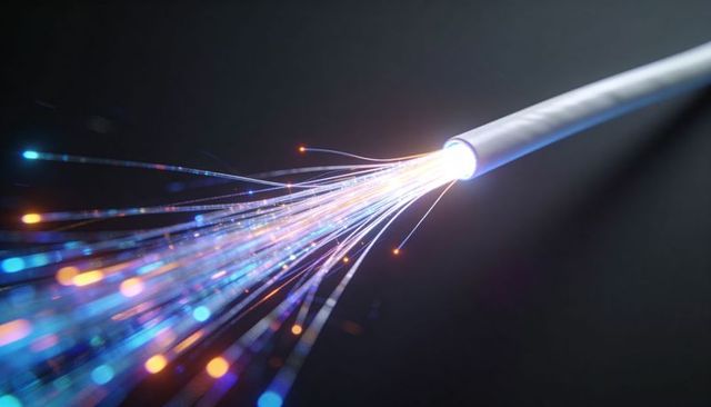 Fiber optic cable emitting illuminated light strands carrying high-speed data with bokeh