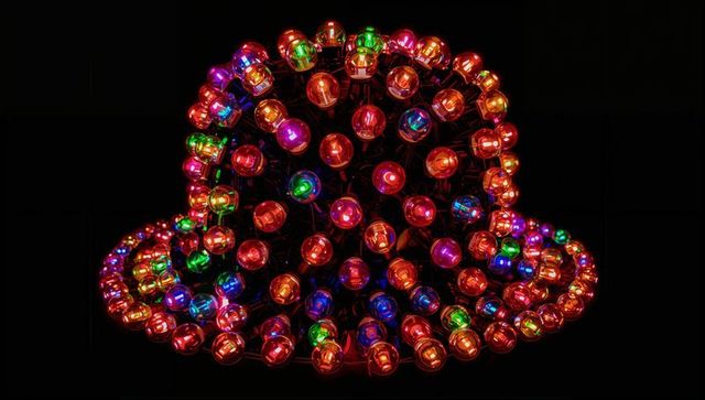Glowing multicolor led bell sculpture creating concentric rings of spherical bulbs on black