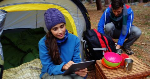 Young Campers using Tablet and Preparing Meal in Forest