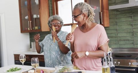 Senior Women Enjoying Cooking Together in Modern Kitchen