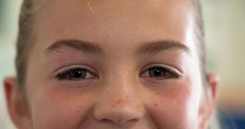 Close-up of child's face revealing freckles and natural joy