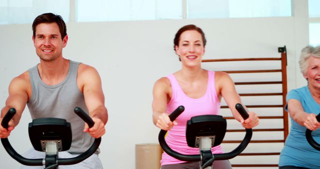 Happy People Exercising on Stationary Bikes in Bright Fitness Studio - Download Free Stock Images Pikwizard.com