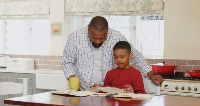 Father and son sitting at dining table, father guiding son through homework. Natural light from window, cozy atmosphere. Use for educational materials, parent involvement promotions, family bonding themes, or advertising for educational tools.