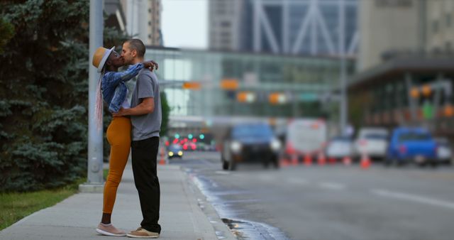 An affectionate couple is embracing on a bustling urban street with buildings and traffic in the background. Ideal image for advertisements, social media content, blogs, and articles focusing on love stories, relationships, urban lifestyles, and city living.