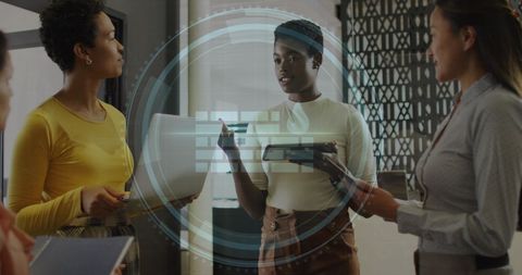 Women discussing cybersecurity in office with holographic display