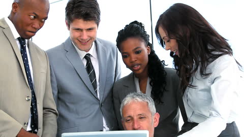 Team Collaborating with Laptop in Modern Office Environment