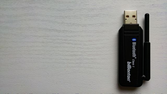 Black USB Bluetooth Adapter on White Wooden Surface - Download Free Stock Images Pikwizard.com